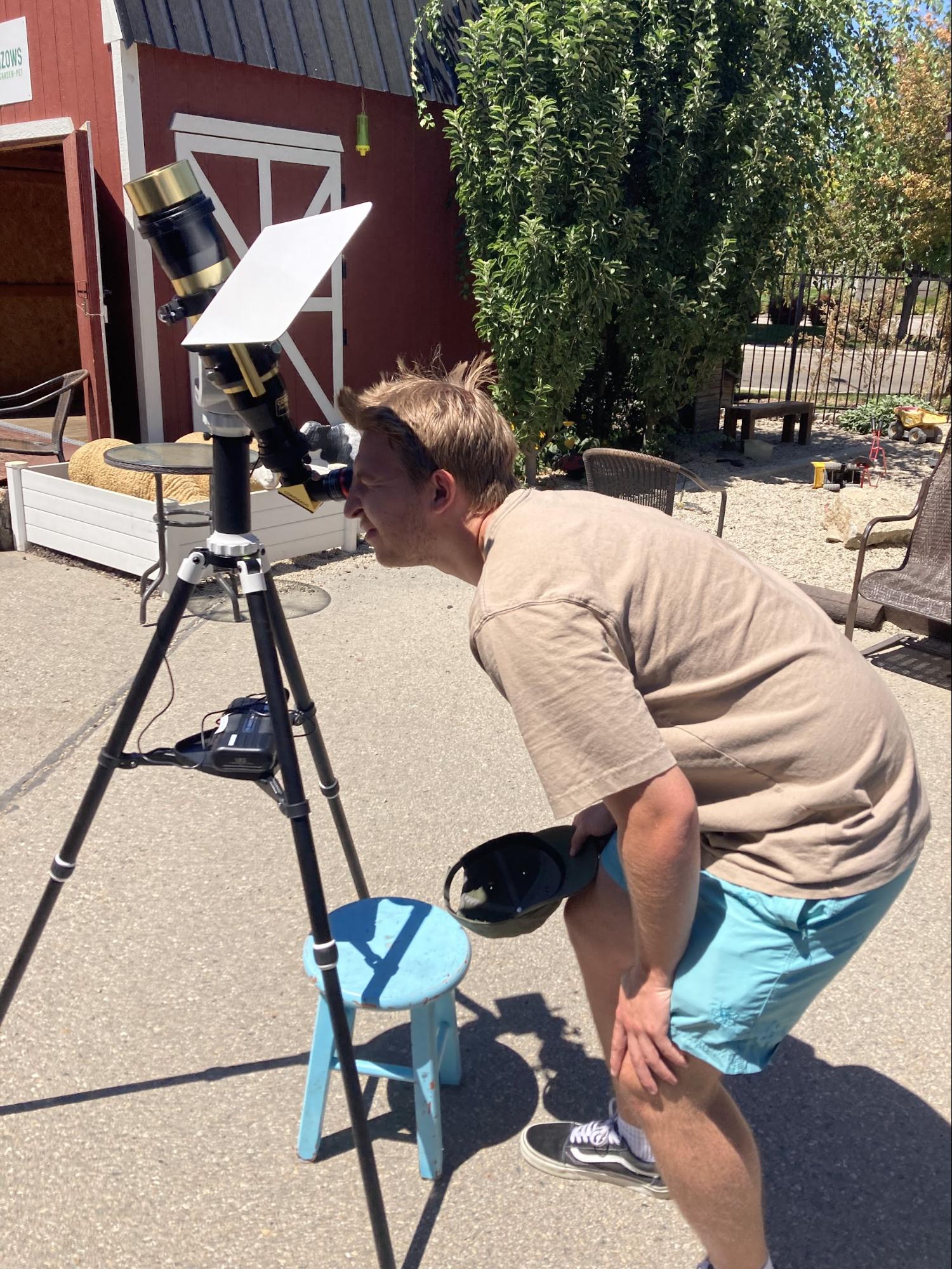 man looking through solar scope