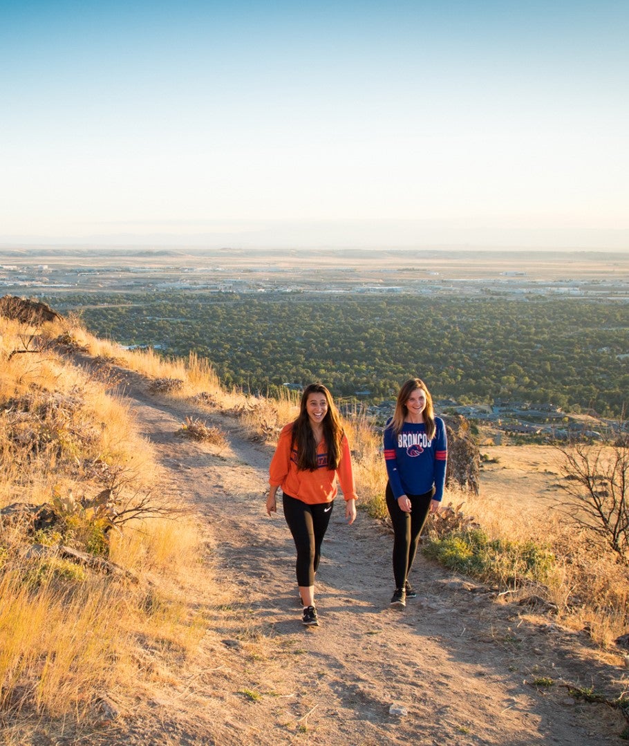 students hiking on hill overlooking city of boise