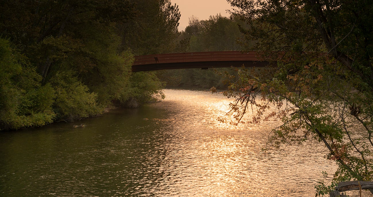 Friendship bridge over Boise River with sun reflecting off the water