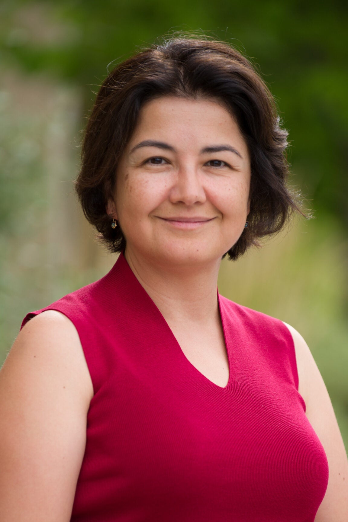 Portrait of Zeynep Hansen, a woman smiling in a red top