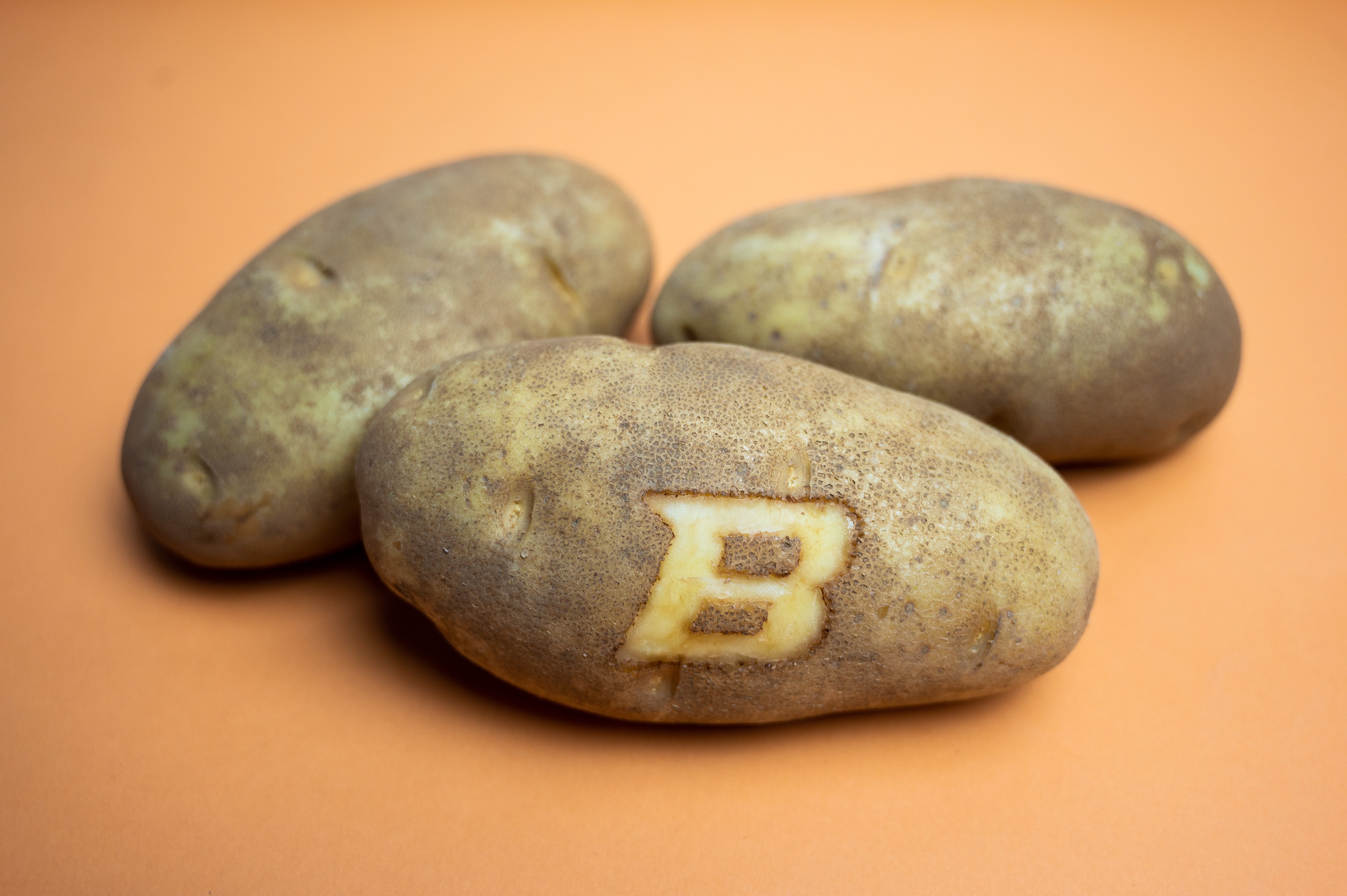 three potatoes and one has a B branded on the front