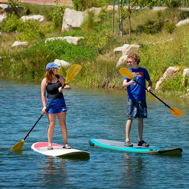 Two students paddleboard on Boise River