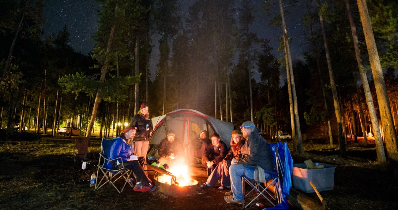 Students camping and enjoying a campfire.