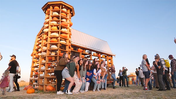 Students pose with a display of pumpkins