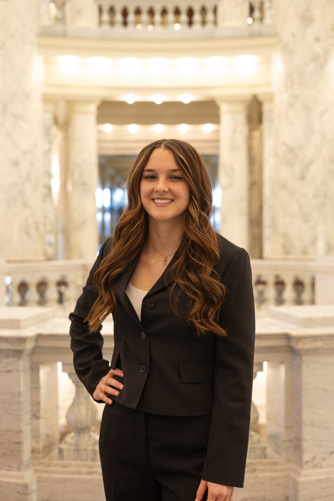 Allie Neet standing in the Idaho Capitol Rotunda with her hand on her hip, smiling
