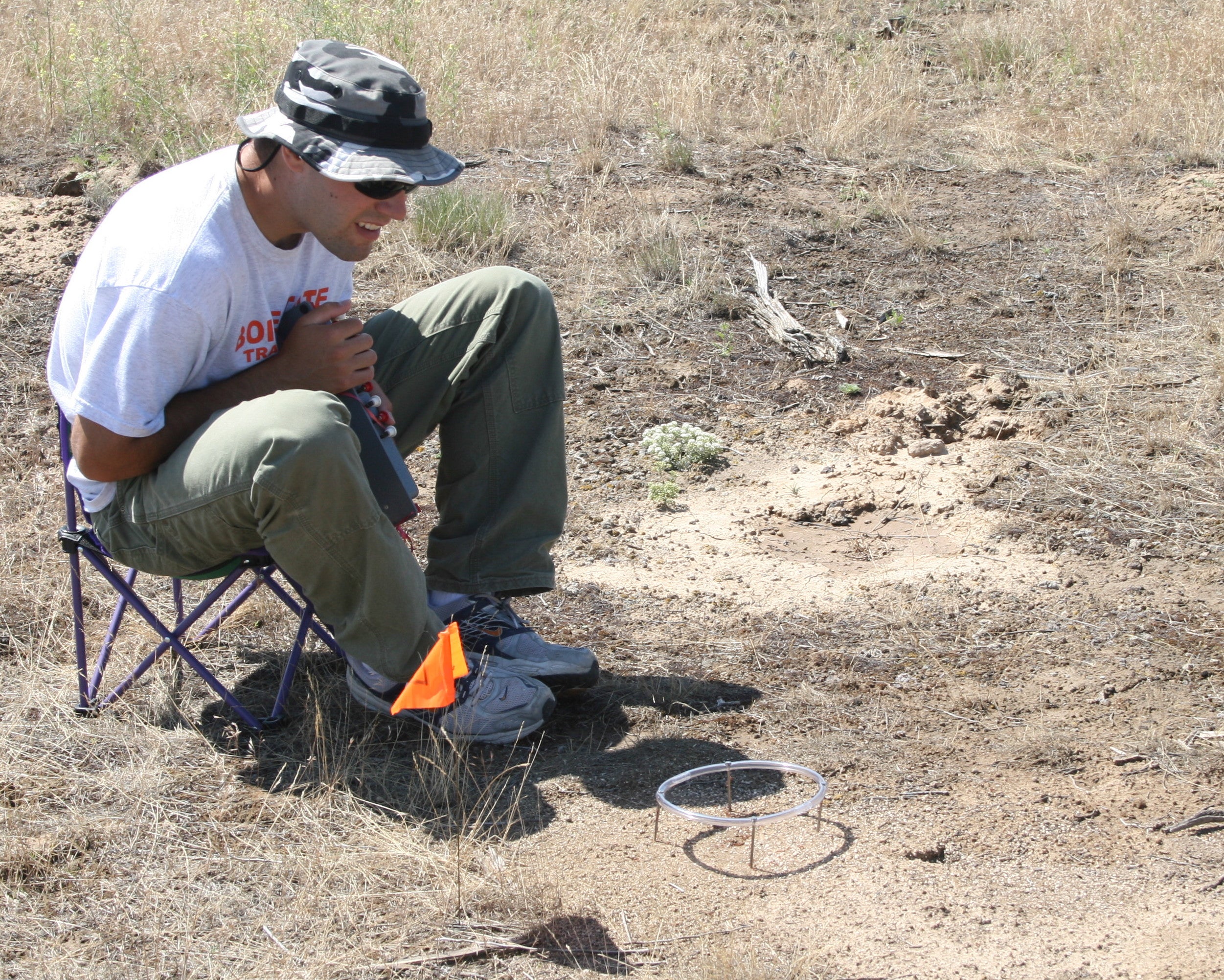 Matthew Schmasow sits in a chair in the field