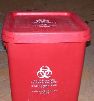 A properly secured biohazard disposal bin. There is no protruding foreign bodies from the lid, and the lid is tightly secured.