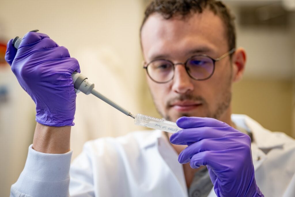Student putting serum into a vial during lab. 