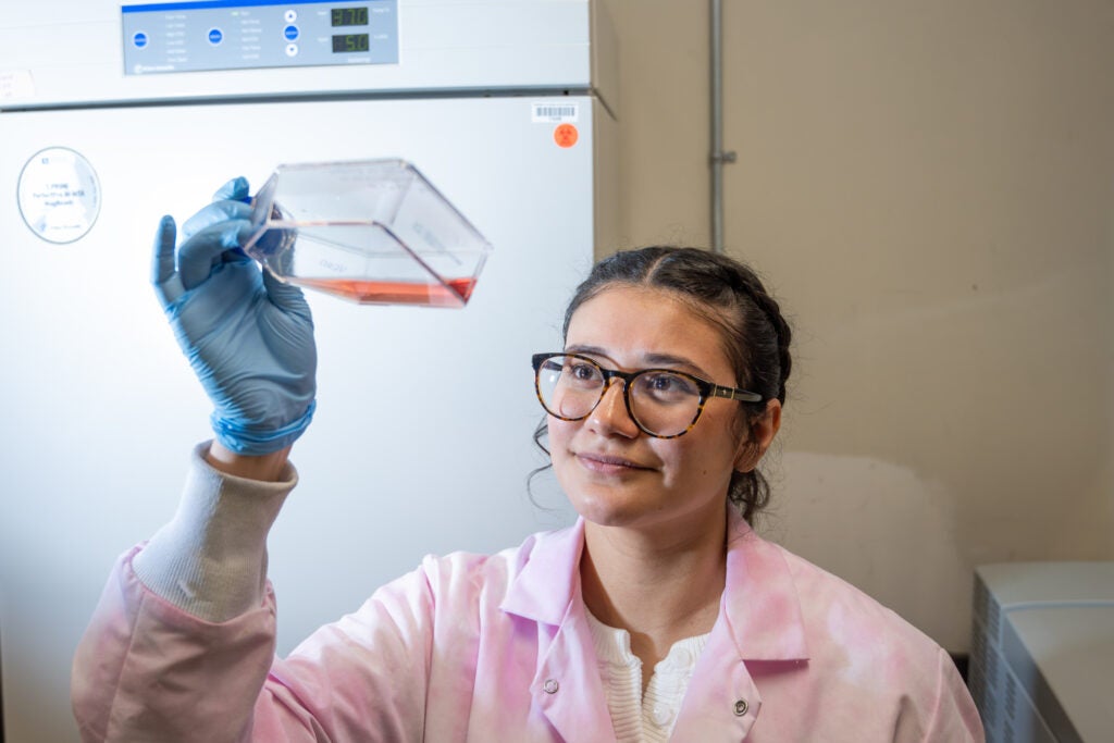 Student holding up lab equipment.