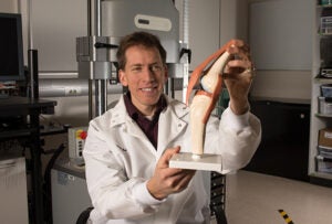 Trevor holds a model of a knee