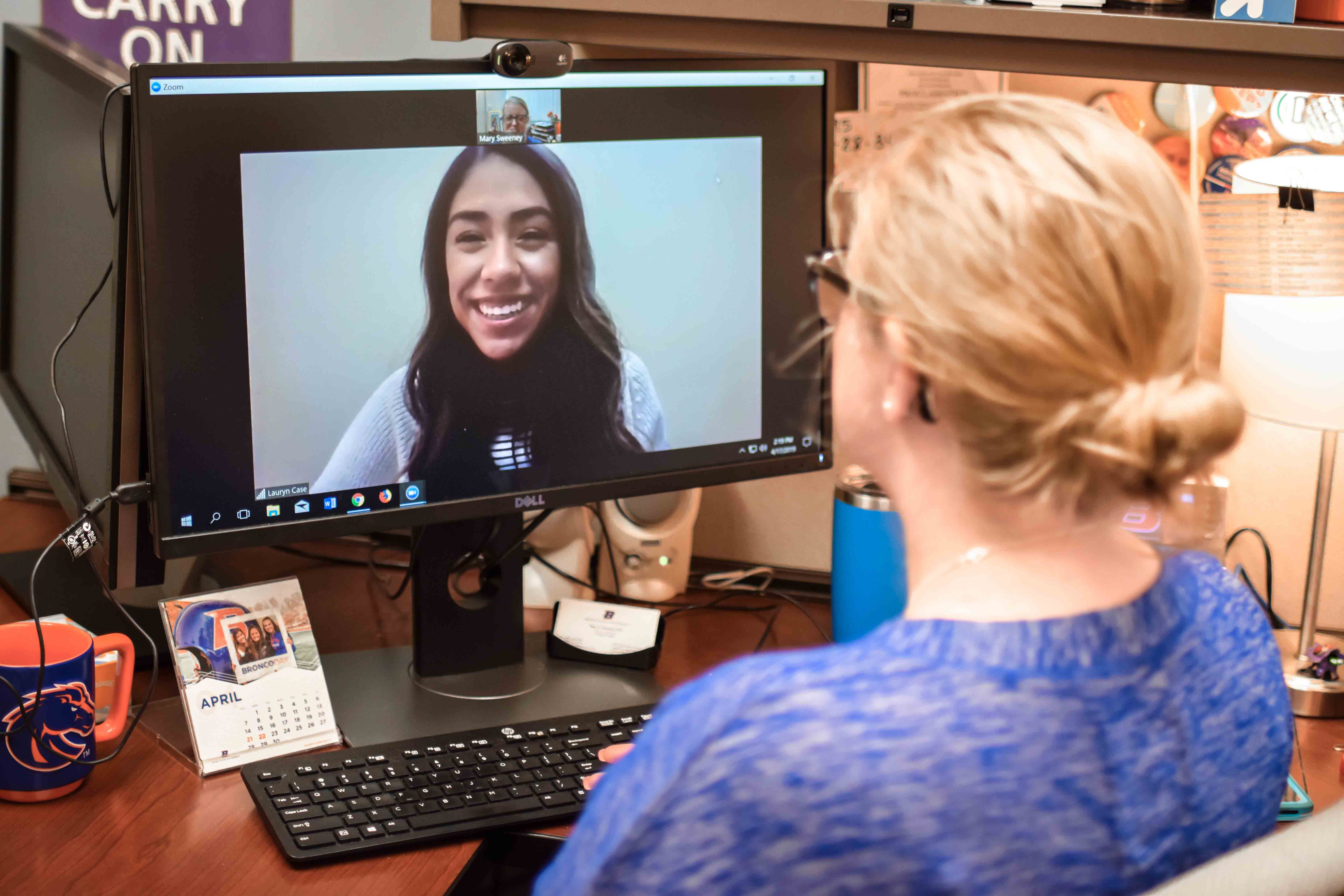Counselor talking to student via video on a computer monitor