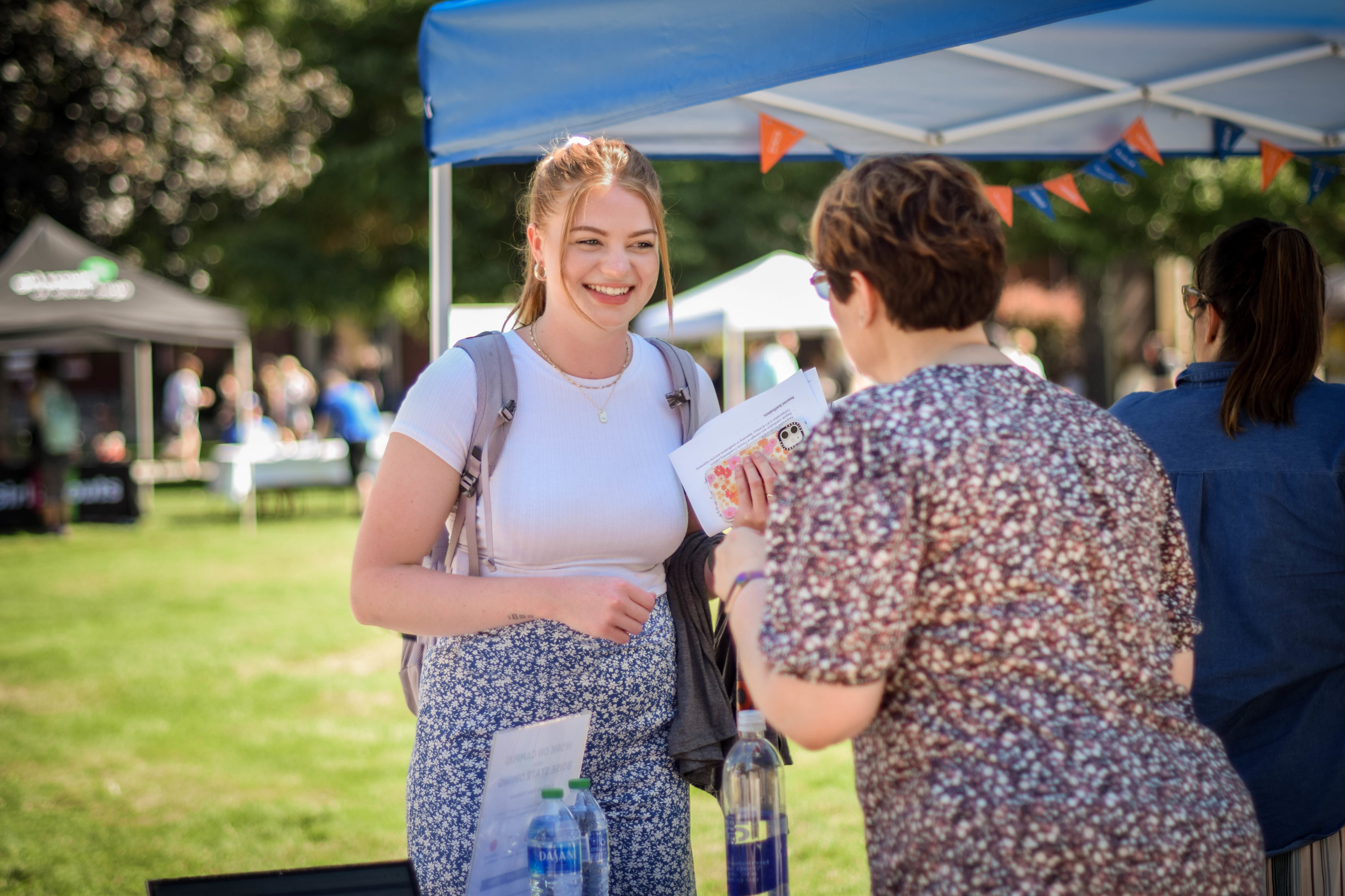 Student smiling at an employer at the Part-Time Job Fair on the Quad