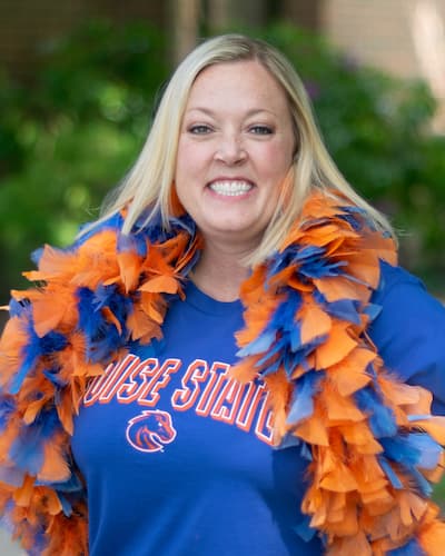 Headshot of Rachel Piepmeyer wearing a blue and orange boa