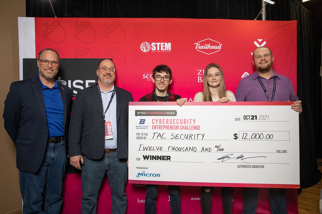 The Cybersecurity Entrepreneur Challenge winning team, TAC Security, holds their large check displaying their $12,000 cash prize. They are joined by Edward Vasko from Boise State and Sam Evans from Micron.