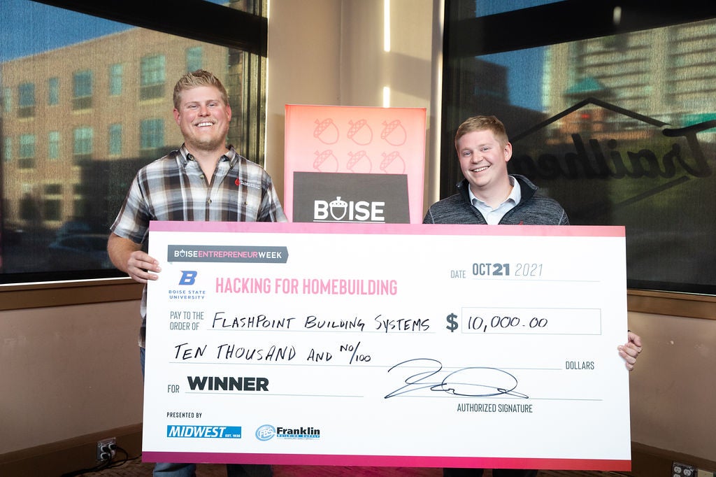 2021 Hacking for Homebuilding winning team, Flashpoint Building Systems, holds a check representing their $10,000 cash prize.