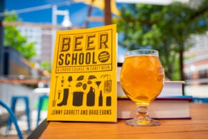 glass of beer next to a book 