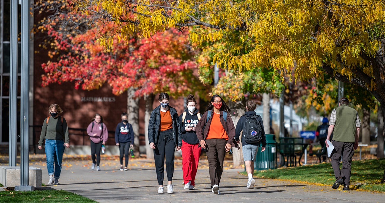 Groups of students walking across the quad at Boise State in the fall