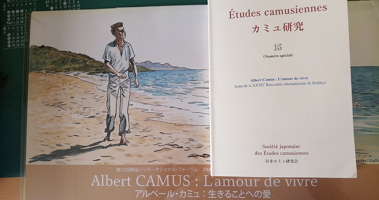 Photo of the poster for the 32nd International Colloquium of Dokkyo with an illustration of a man and the title of a special edition publication titled "Albert Camus: L’amour de vivre (Albert Camus: Love of Life)”