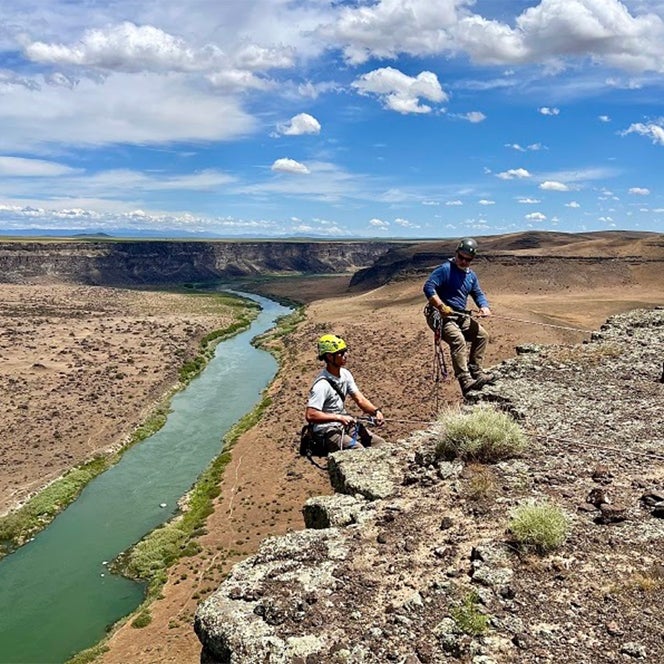 Two researchers repel by rope above the Snake River canyon in Idaho