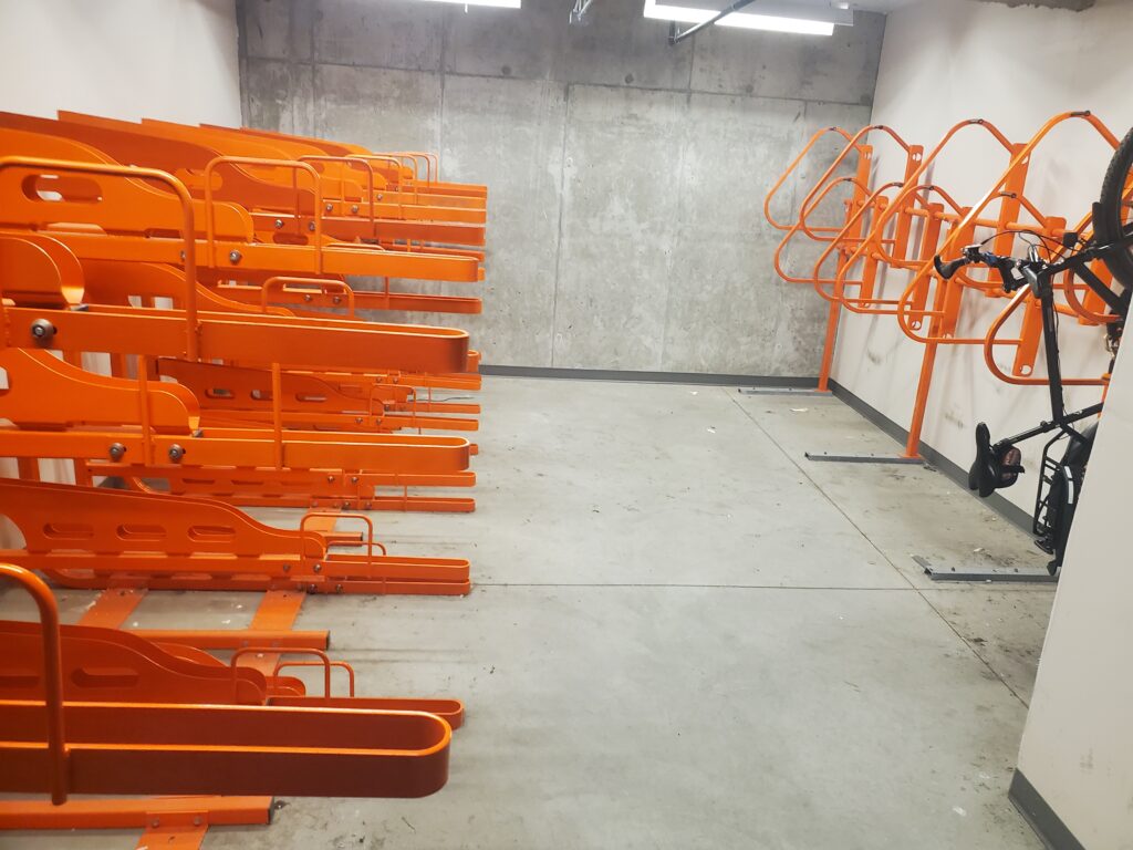 Photo of inside of bike storage facility with orange bike racks
