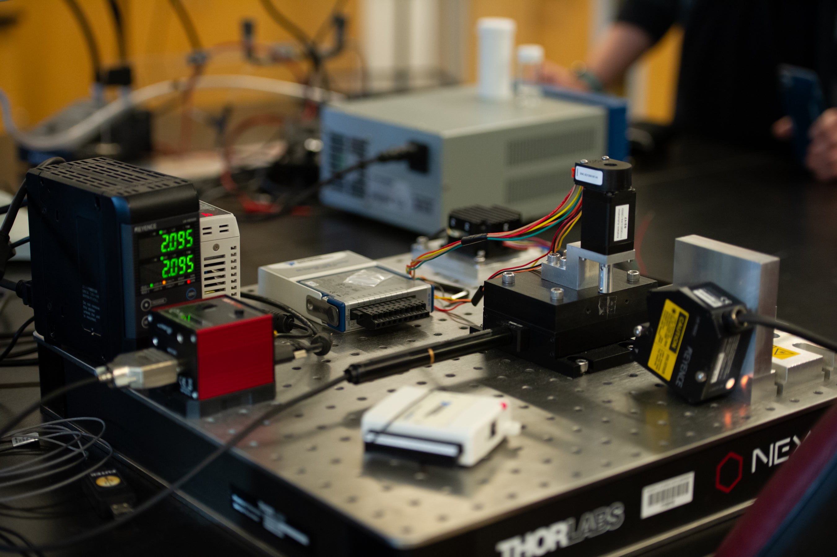 Laboratory setup with various electronic devices and wires on a workbench