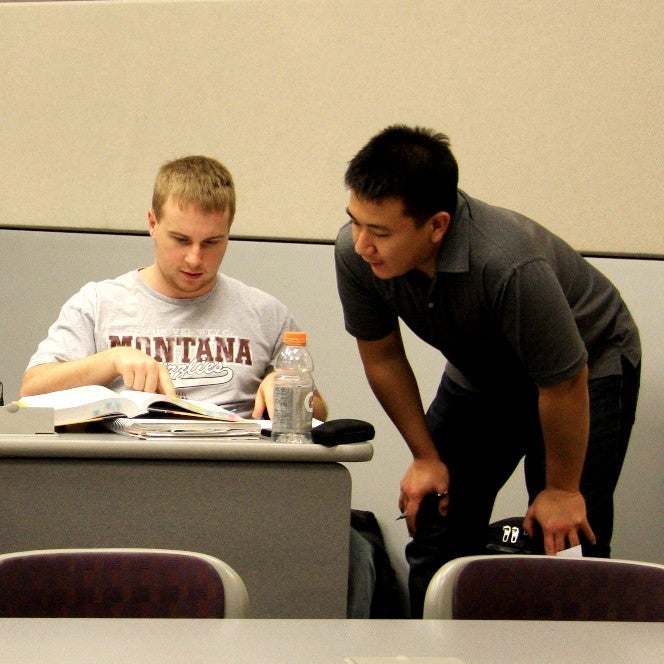 an assistant helps a student in class