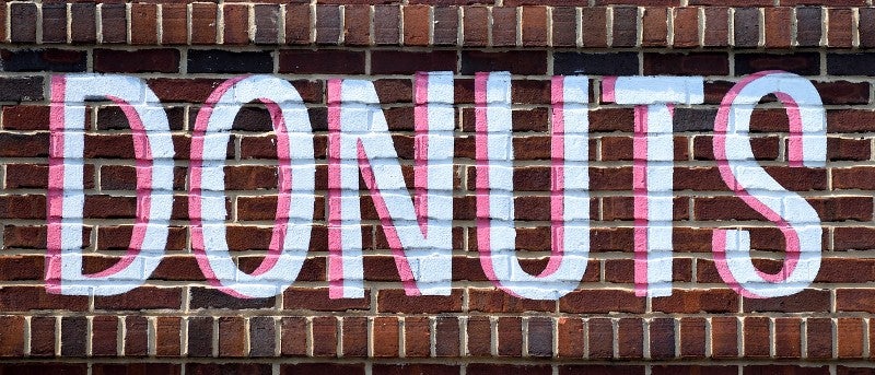 "Donuts" written on a brick wall