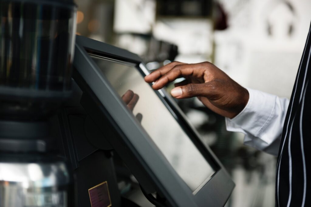 A hand hovers over a touch screen