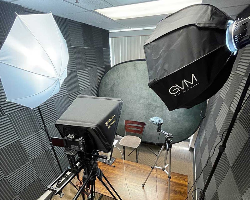 photo and video production studio with lights, camera, chair, and covered walls