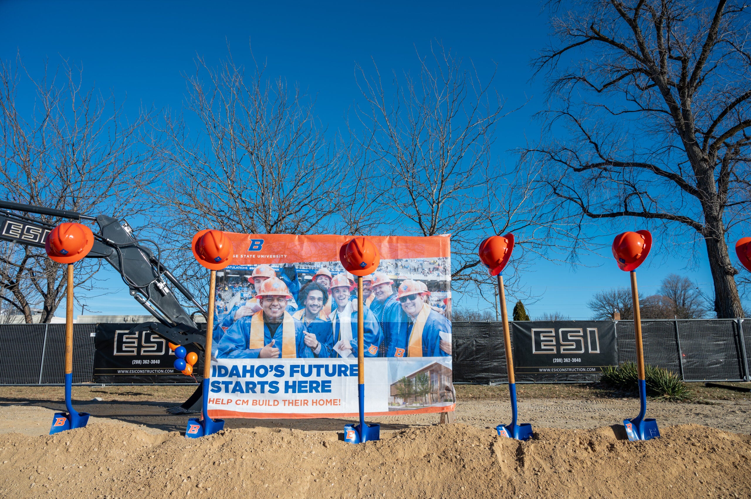 Hard hats hang from shovels for the ESI Construction Management Building groundbreaking