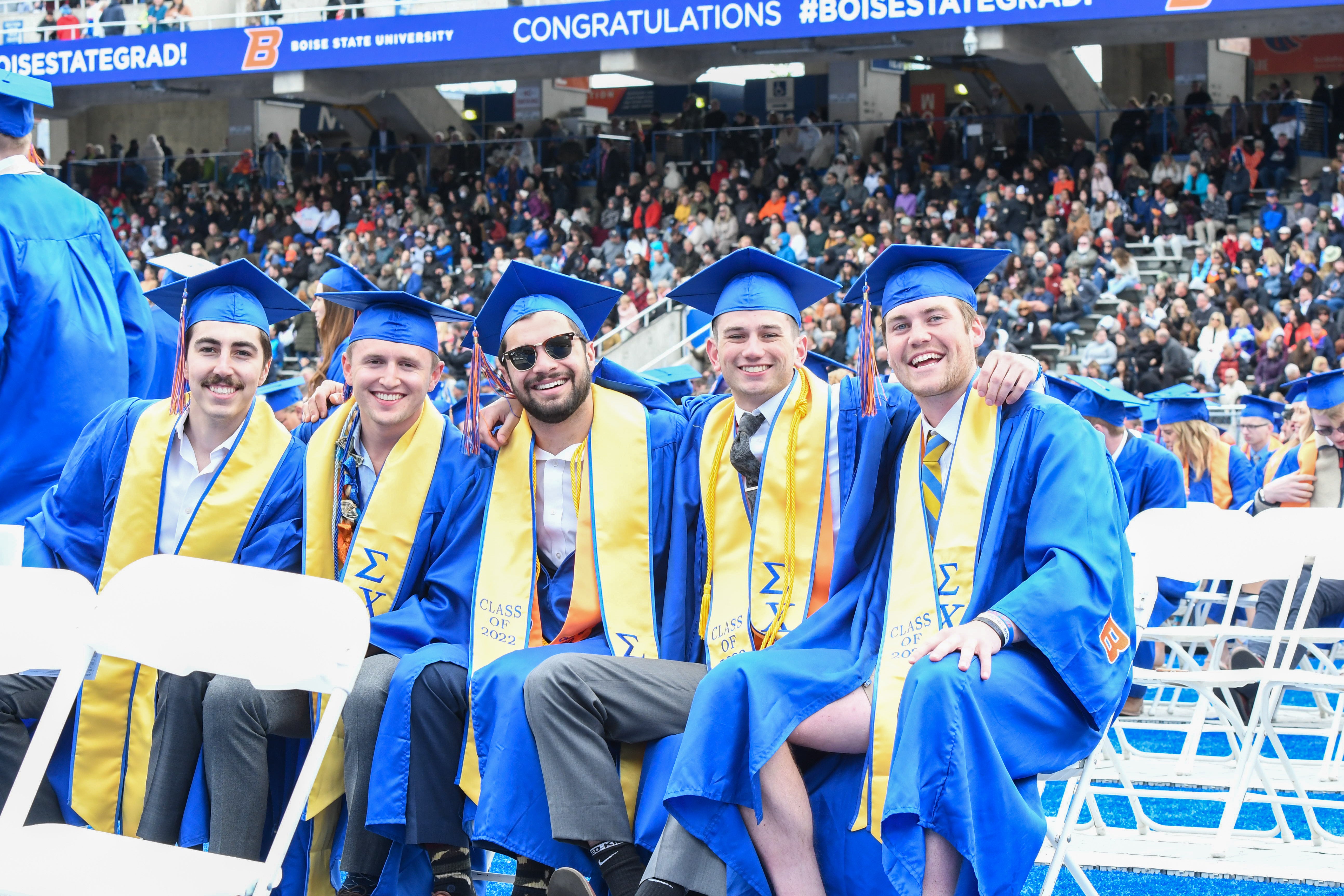 group of students sit together at commencement