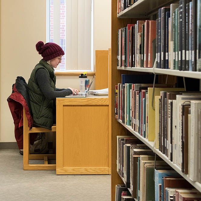 Student studying at desk in library