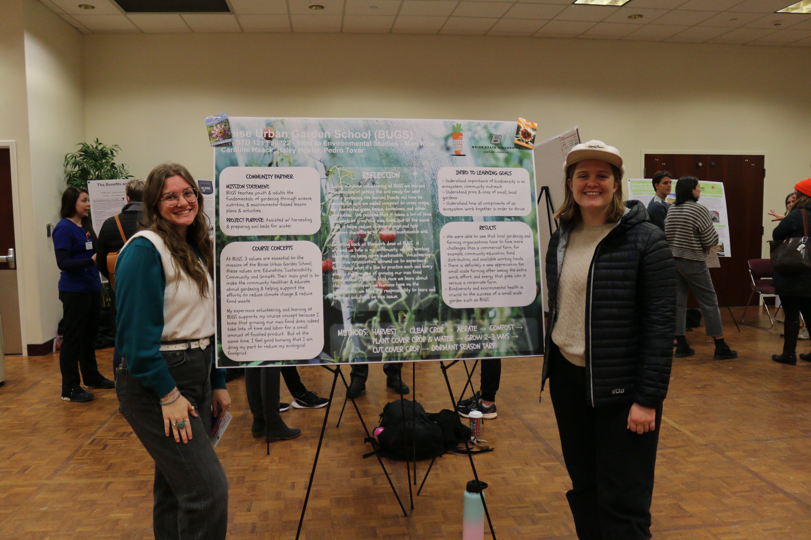 Students stand beside Service Learning project poster
