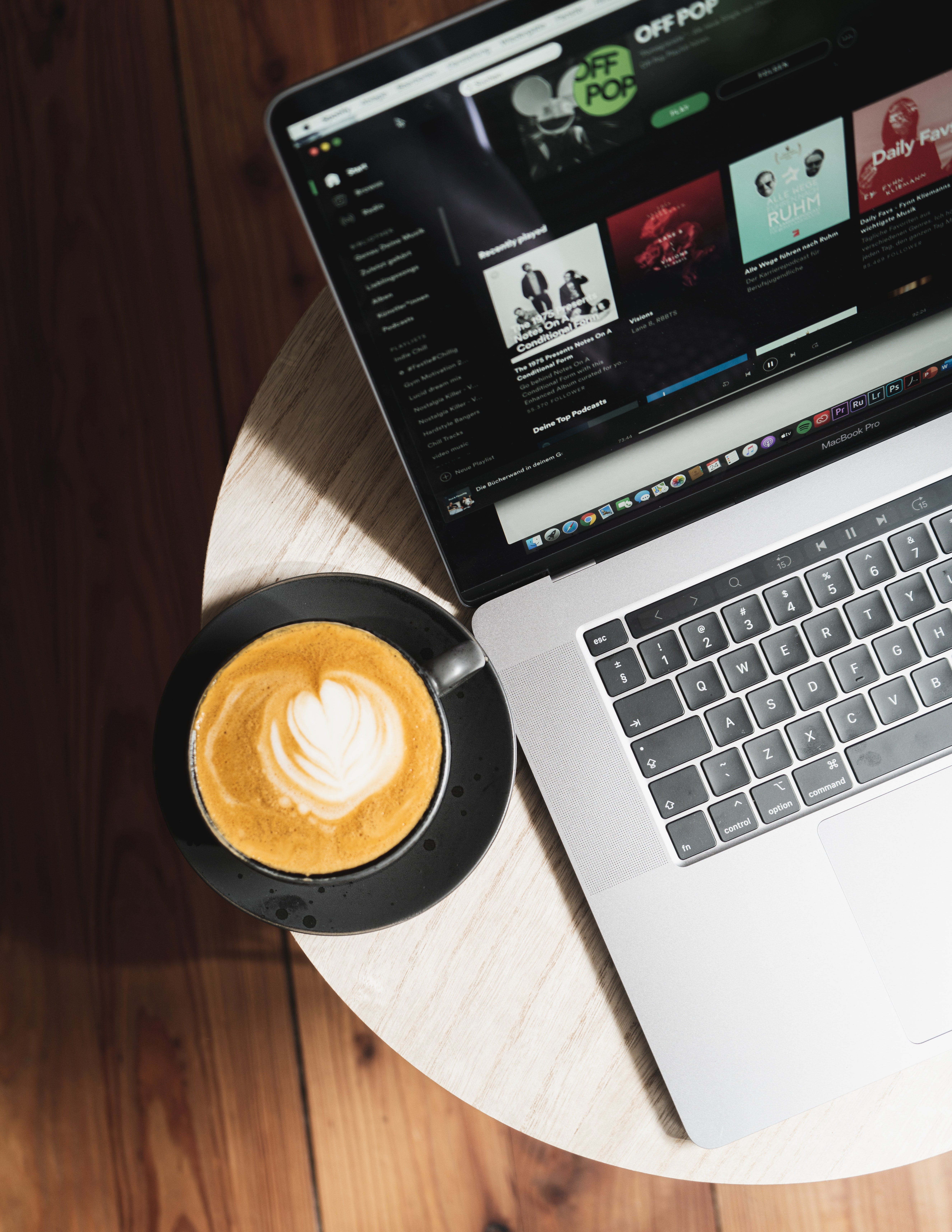 Latte and laptop rest on a coffee shop side table