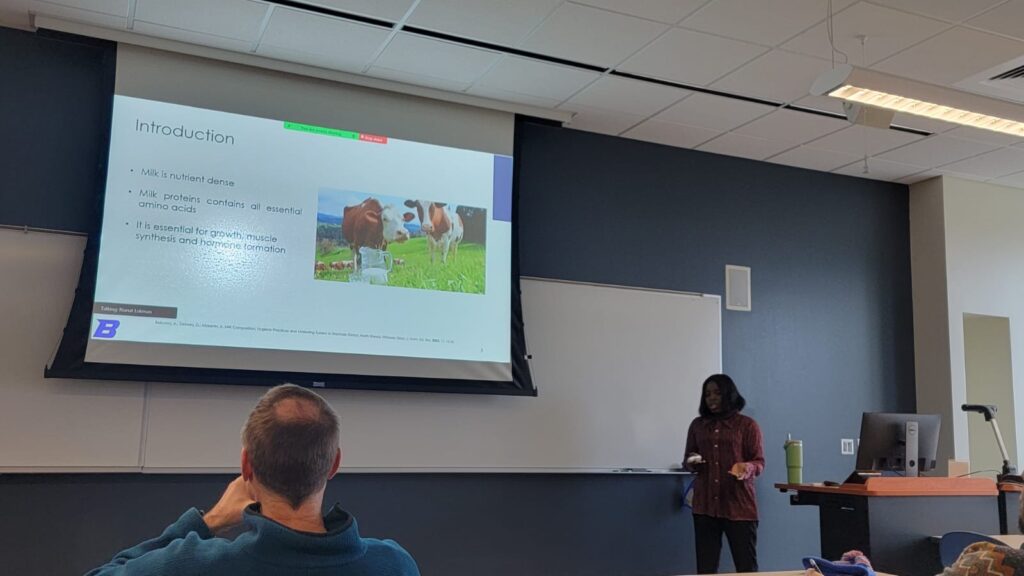 Photo of Rianat Lukman and a presentation slide titled, "Introduction" featuring a picture of cows
