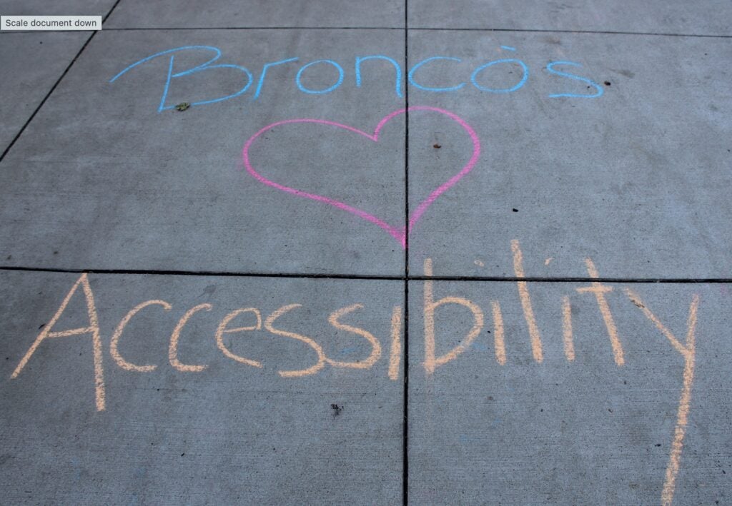 Broncos Love Accessibility written on the sidewalk in chalk.