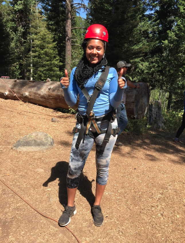Student in zipline gear smiles for camera