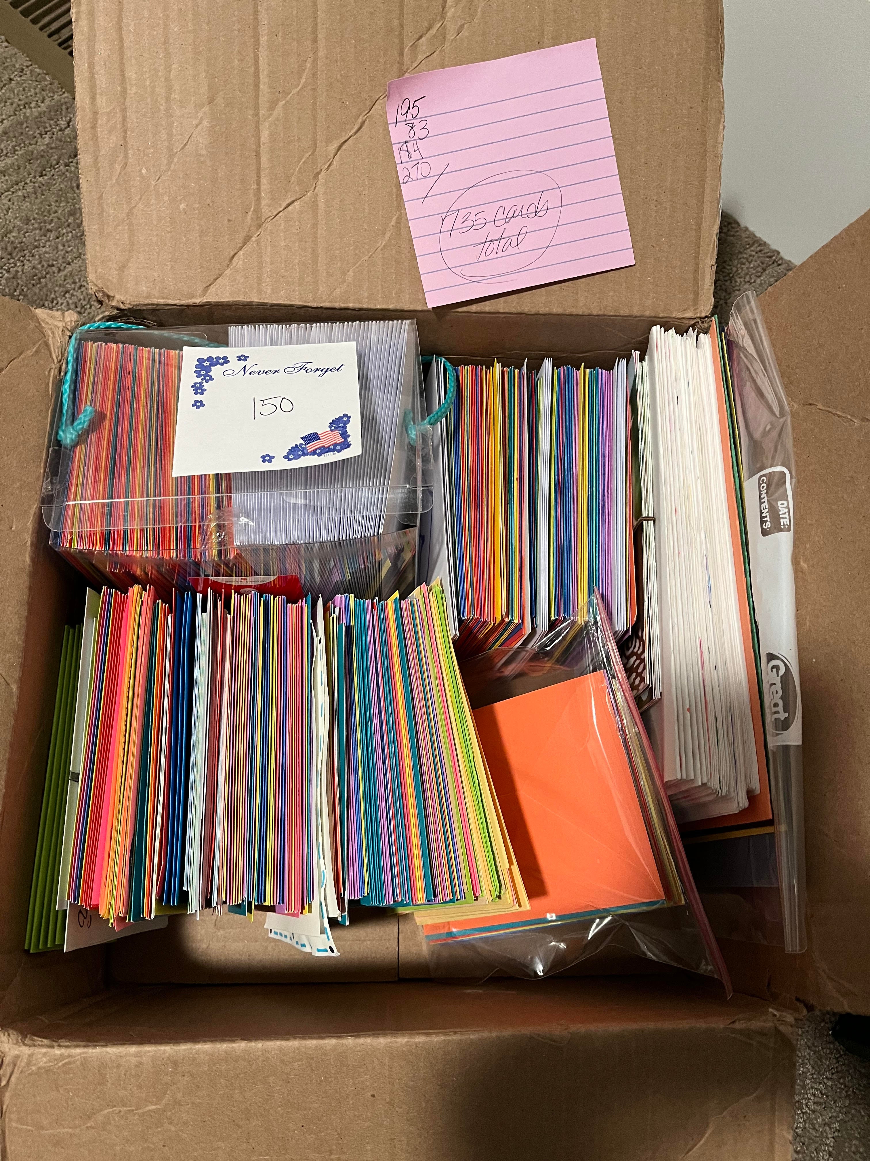 A photo of a cardboard box filled with 735 hand-drawn thank you cards in various colors and sizes.