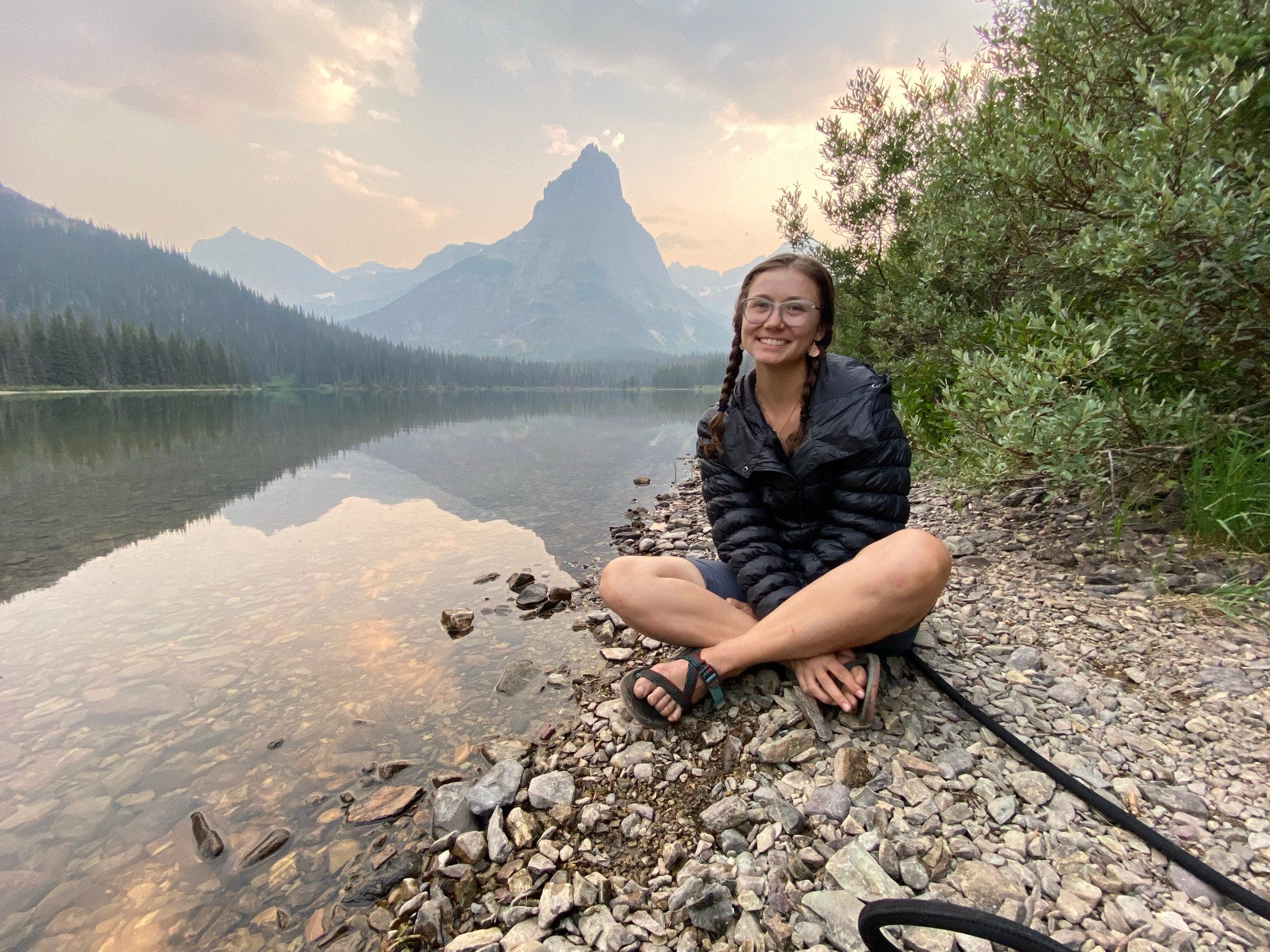 Image of Teacher Prep student Phaeren Roby sitting in front of a lake with a mountain in the background