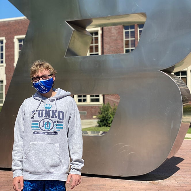Carter Anderson pictured on campus in front of the B statue