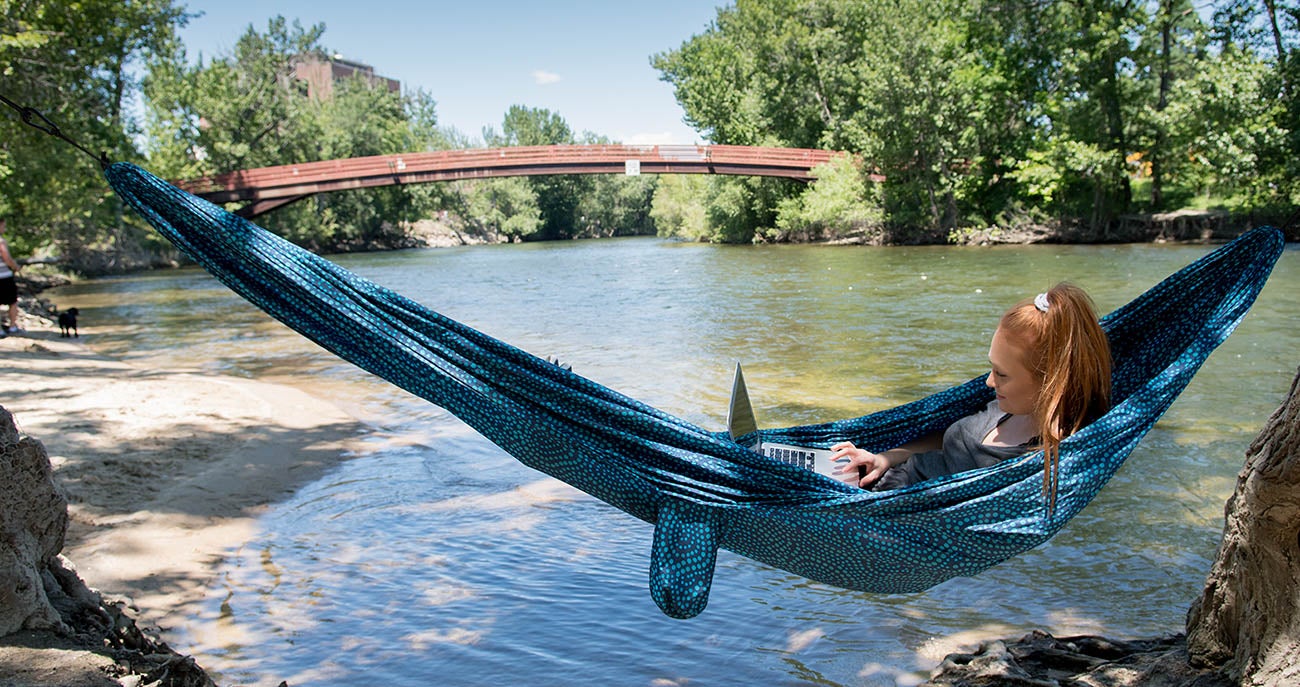 Student in a hammock by the river.