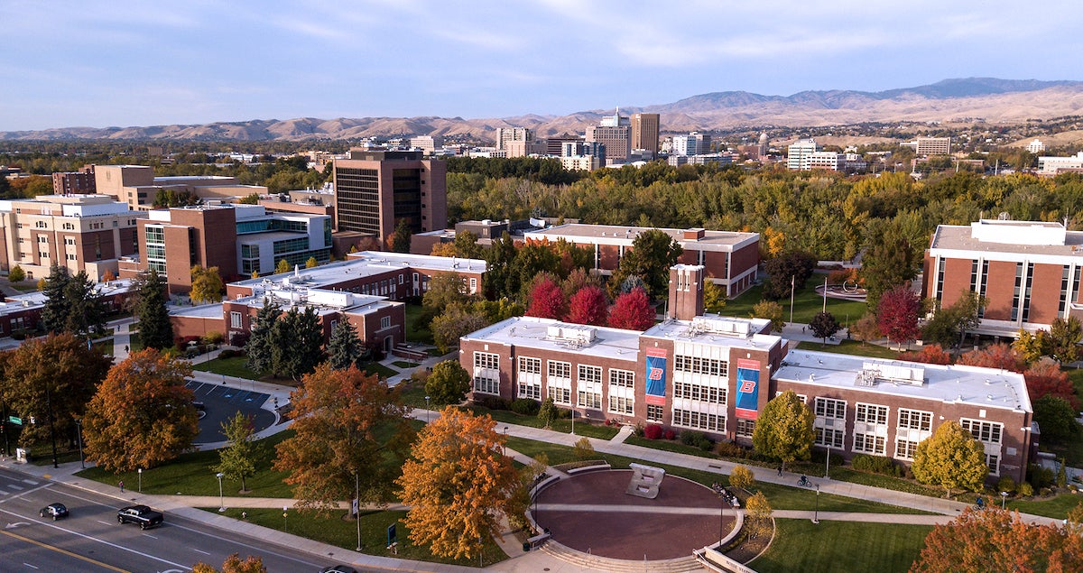 Aerial view of the Boise State campus with downtown and mountains in the distance