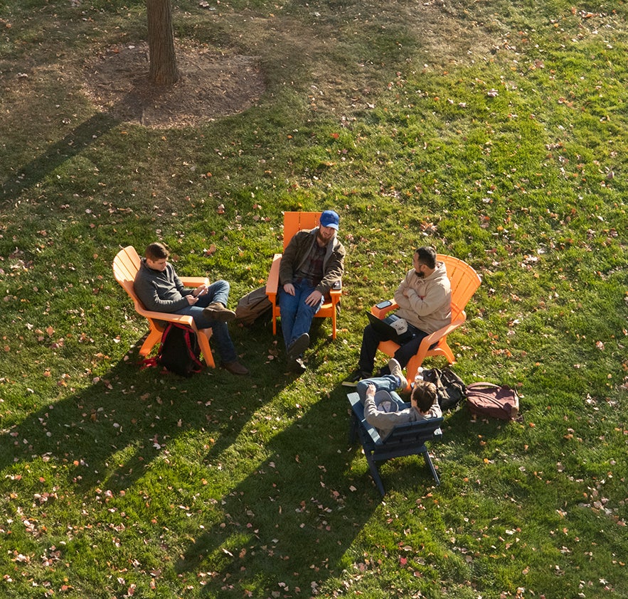 Arial view of students sitting outside in a group