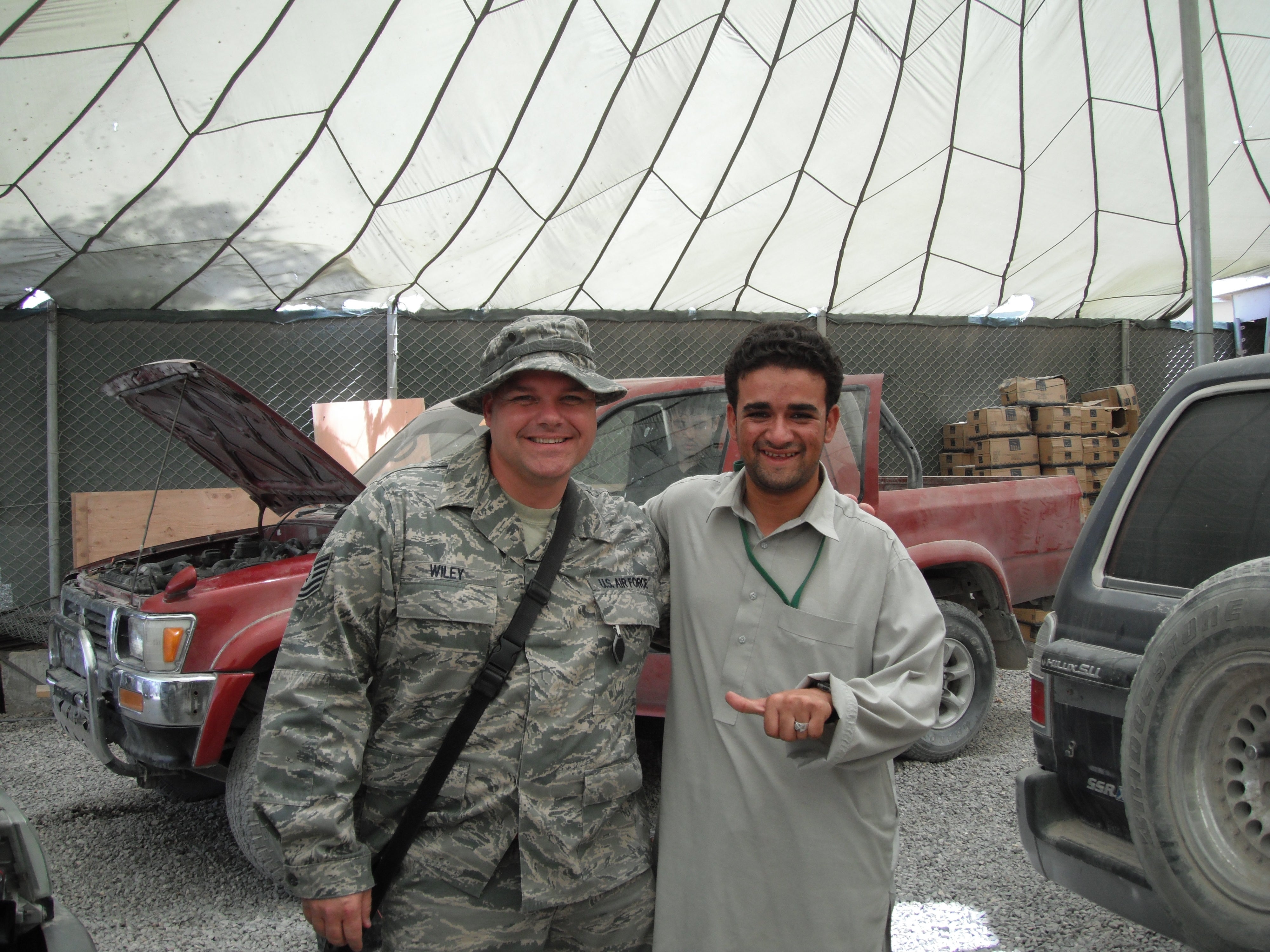Robert Wiley Jr. (left) alongside a Pakistani car mechanic in Afghanistan. Wiley served 21 years in the Air Force and will earn a Master of Science in Cyber Operations and Resilience online degree in August 2022.
