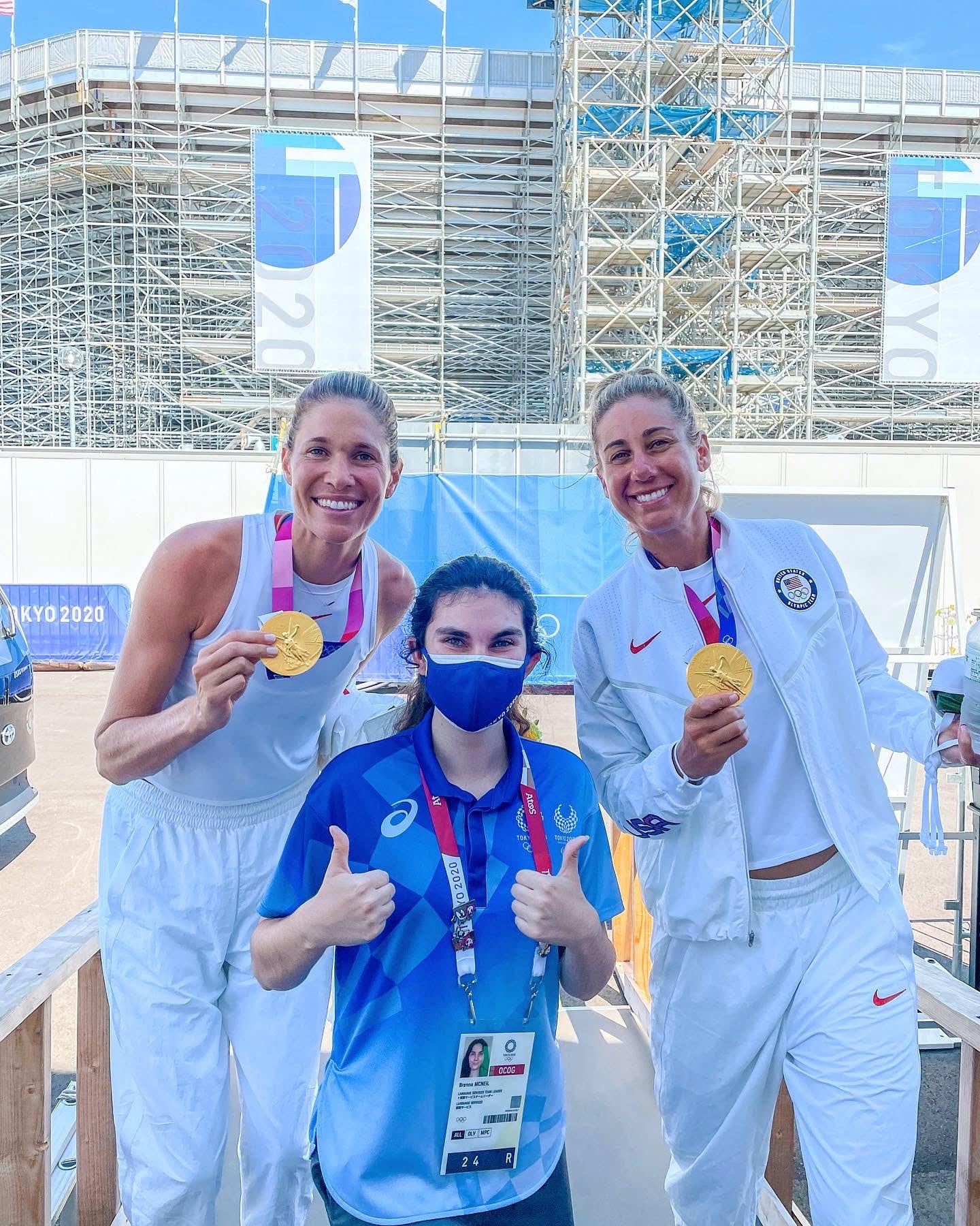 Brenna McNeil in Tokyo with American women’s beach volleyball gold medalists April Ross and Alix Klineman.