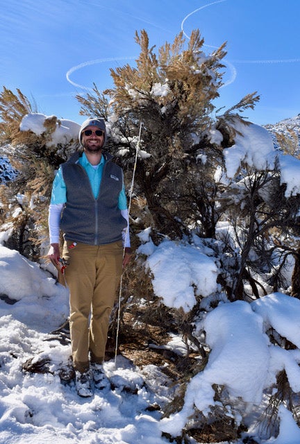 Anthony Melton standing in snow covered sagebrush steppe