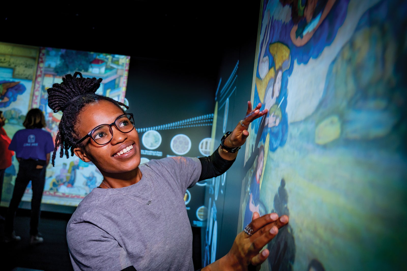 Female African American student interacting with the Luminary art screen