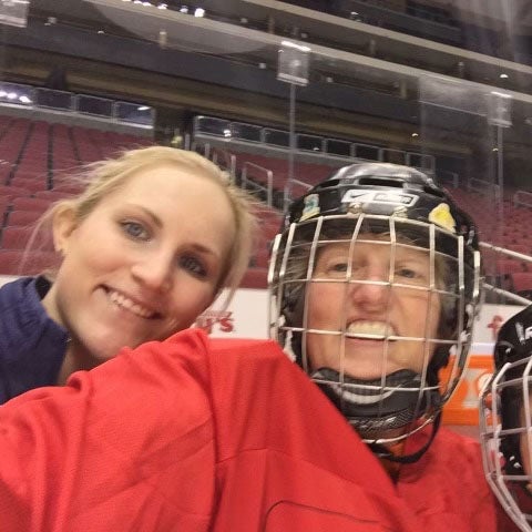 Lynda Ransdell in her hockey helmet taking a break with retired women’s hockey Olympian Monique Lamoureux