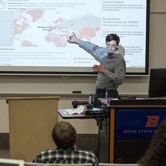 A professor pointing at a map in a lecture hall.