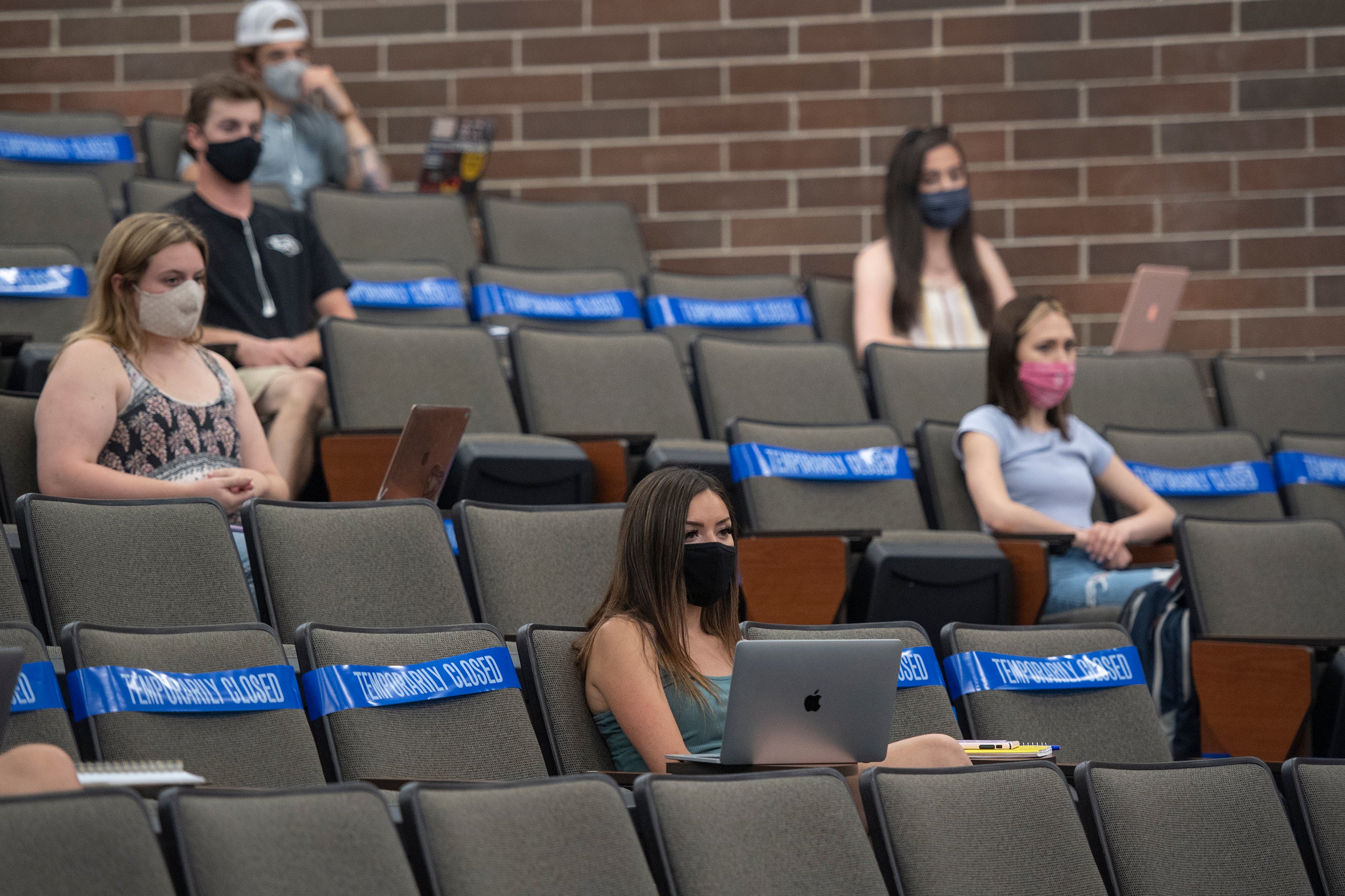 Students sitting in a lecture with masks on while socially distancing